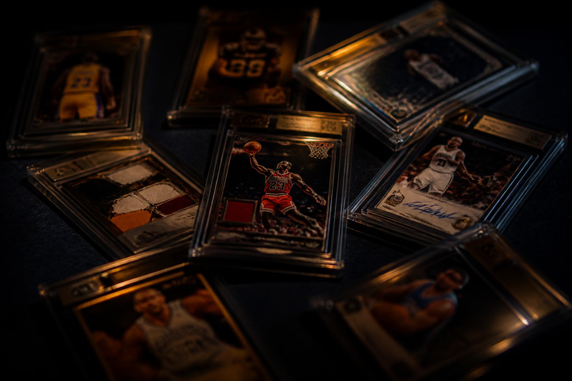 Graded sports trading cards in protective slabs under warm light